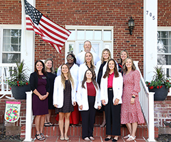 Faculty and students enrolled in the Wisdom Family Foundation Doctoral Program for Rural Nursing Practice pose for a group photo with Northwestern President Dr. Bo Hannaford outside the President’s House during residency week. Top Row: Northwestern Oklahoma State University President Dr. Bo Hannaford. Middle Row, left to right: Dr. Krista Tilley, Juane Russell, Michelle Milligan, Kyndall O’Donnell, Dr. Gwyneth Holderby. Bottom Row, left to right: Dr. Sandra Watson, Alyssa Los, Tierna Adair, Sara (Garvie) Wilber, Dr. Leslie Collins.