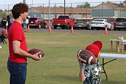 A Northwestern student (left) plays a carnival game with a local kid (right) at the 2024 Northwestern Carnival.