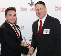 SGA president Braydon Stoner presenting Dr. Dean Scarbrough with the John Sheffield Teacher of the Year award.